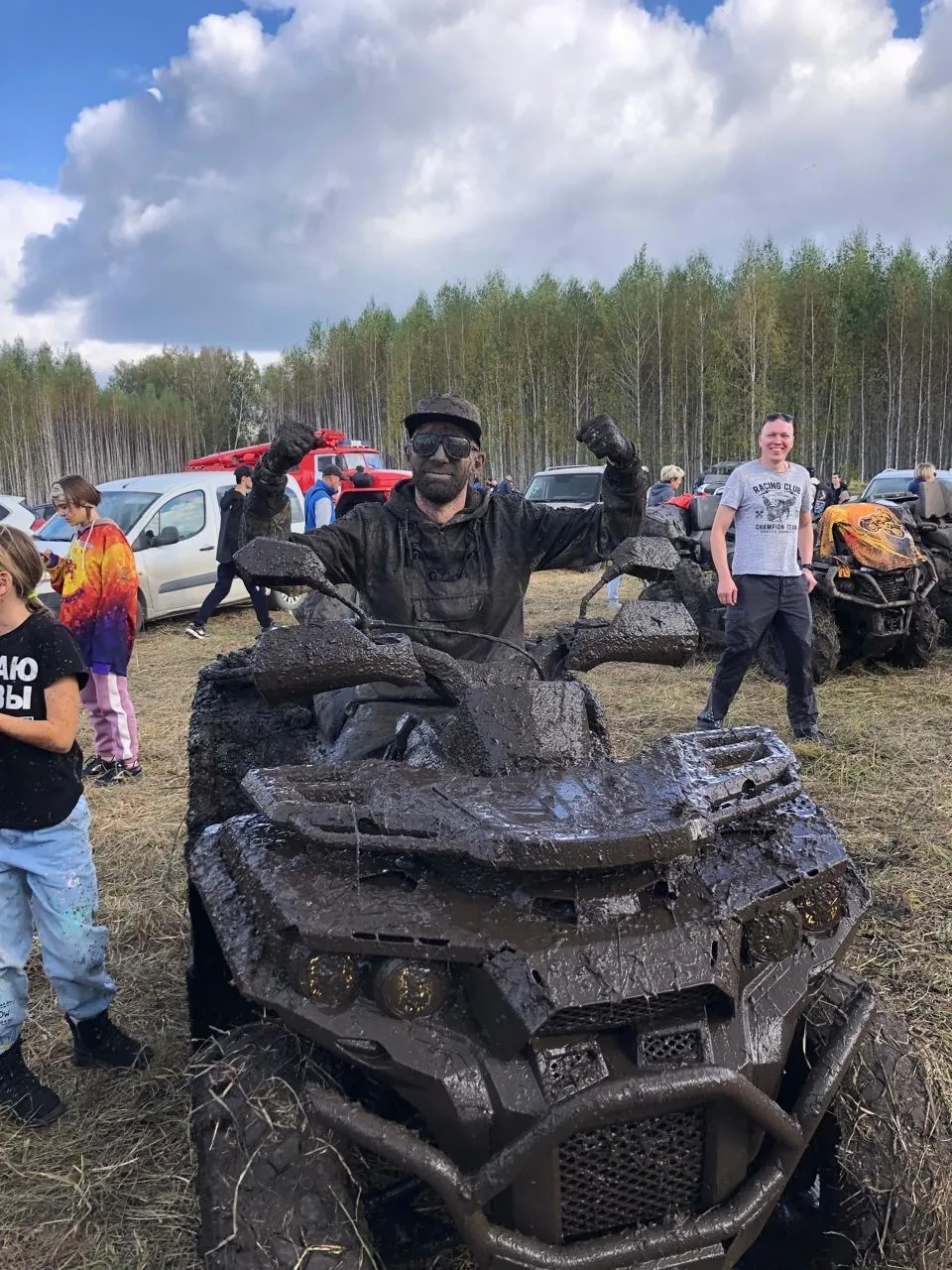 Участник клуба на квадроцикле после грязевого заезда
